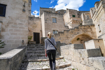 Woman walking up stairs in Matera Italy