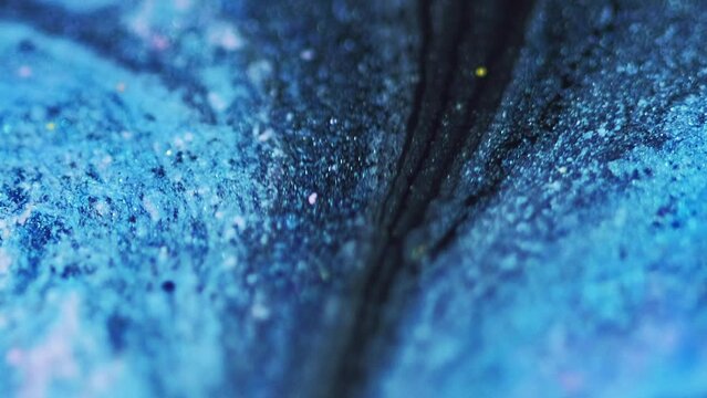 Glitter paint drip. Sparkling fluid wave. Defocused blue black color shimmering texture liquid ink blend flow motion abstract art background.