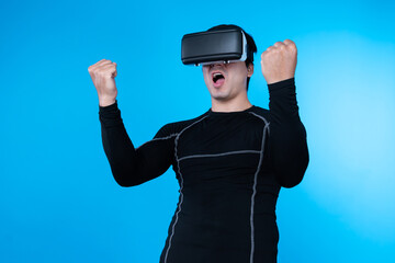 Smart gaming player wearing VR glasses raising fist up isolated blue background screen connecting...