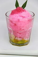 Es doger made from sugared sweet coconut milk based ice in pink syrup, served with red tapioca pearls, avocado, cassava tapai, black glutinous rice, jackfruit, diced bread and condensed milk.