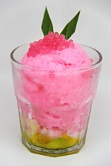 Es doger made from sugared sweet coconut milk based ice in pink syrup, served with red tapioca pearls, avocado, cassava tapai, black glutinous rice, jackfruit, diced bread and condensed milk.