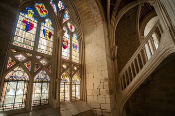 Obraz premium A medieval castle with towering stained glass windows showcasing the heraldic symbols of noble families, adding a touch of grandeur, Generative AI