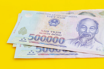 Vietnamese dong banknotes on yellow background.