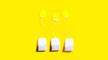 Tea bags on yellow background.