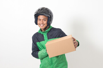 Portrait of Asian online courier driver wearing green jacket and helmet delivering package and box for customer. Isolated image on white background