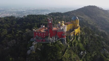 Colorful Pena Palace in Sintra, Portugal, Slow Pan Right, Wide Landscape View: Aerial Drone View, Bright Castle Near Lisbon, Bright Sunny Day. Europe Travel Destination, UNESCO World Heritage Site