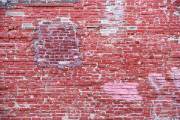 Old red brick wall with patches in the background