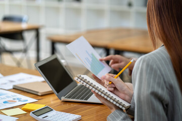 Two Asian businesswomen working Creative discussion in office using laptop and tablet, business concept