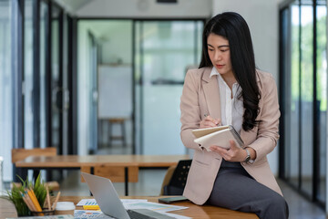 Asian business woman working In office using laptop and tablet, business concept