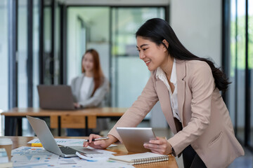 Asian business woman working In office using laptop and tablet, business concept