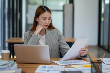 Asian business woman working In office using laptop and tablet, business concept
