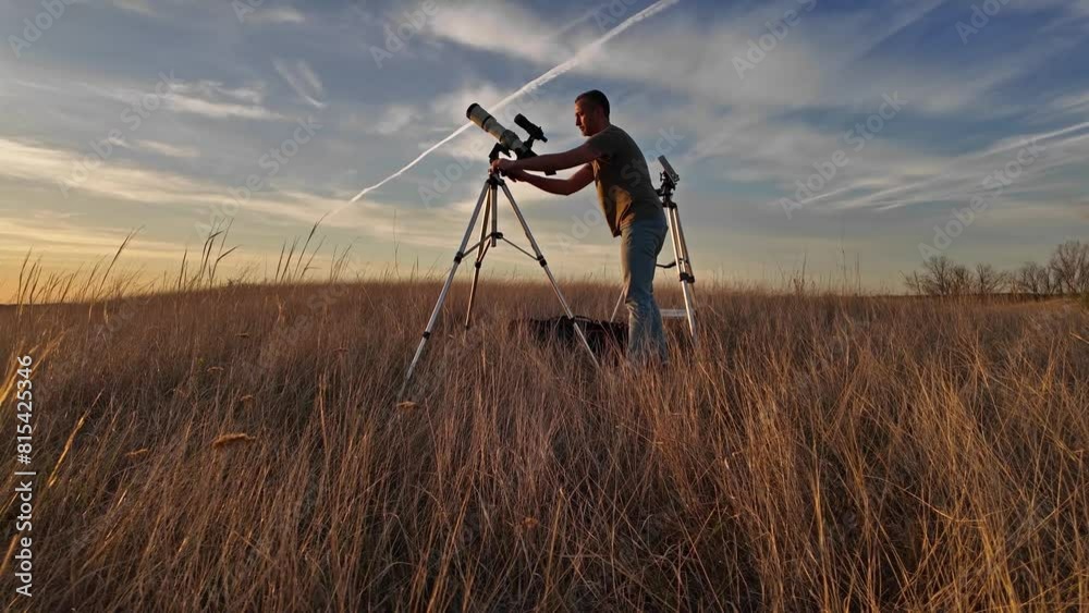 Wall mural amateur astronomer observing solar eclipse and sun with a telescope and special solar filter.