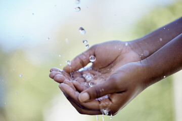 Hands, splash and person with water in nature for bacteria washing, hydration or body hygiene....