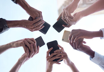 Group, low angle and hands with smartphone in networking, social media and online, digital and...