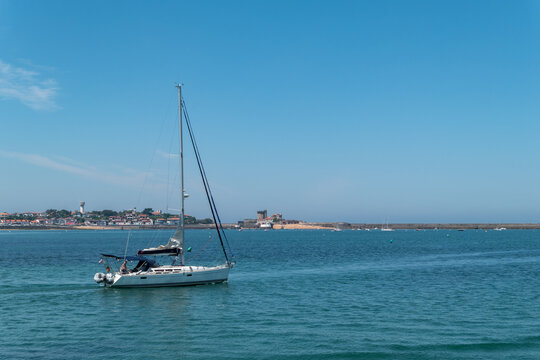Um barco a navegar no mar com parte da cidade e do porto de Ciboure ao fundo no Pa&iacute;s Basco franc&ecirc;s