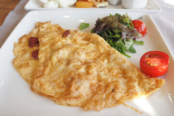 Plain Egg Omelette served with fresh salad on table 