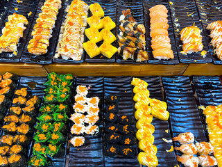 Sushi and rolls on a market display as a background