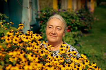 Senior woman near the flower in the countryside