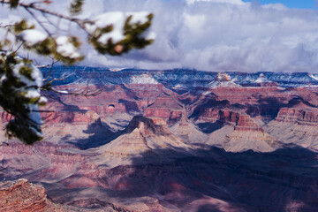 Wintry Veil Over the Grand Canyon with Snow and Clouds