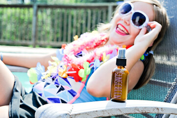 Joyful young girl laughing with sunscreen, poolside on a sunny d