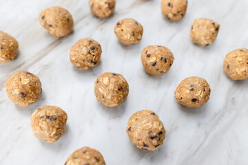 Energy balls displayed on a marble surface, oat peanut butter snacks