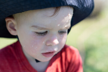 Close-up of a toddler face speckled with water
