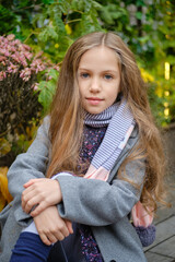 Portrait of cute little girl in coat and scarf