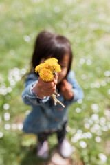 Toddler holding flowers on a Sunny Day