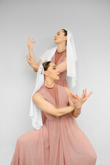Two female dancers perform hand movements