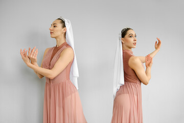 Ballerinas standing on grey background and perform hand and palms movements