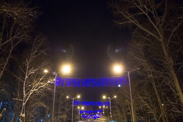 garland in the park. New Year's decor of the city for Christmas. Festive mood.