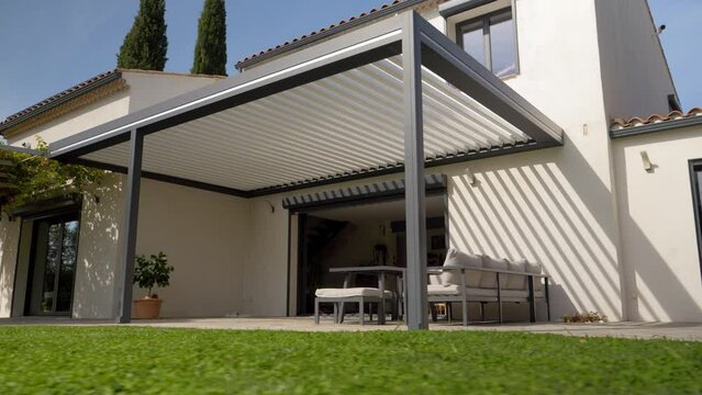 Low angle shot of a sun shade with garden furniture sitting outside a villa