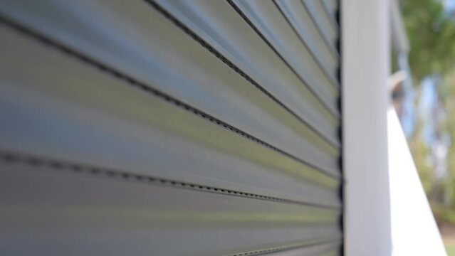 Close-up shot of a automatic garage door closing with bright sunlight