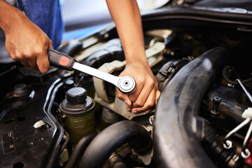 Person, hands and mechanic with spanner for fixing engine in workshop for motor maintenance and...