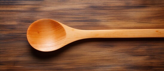 A wooden kitchen spoon placed on a wooden background offering ample copy space for adding text