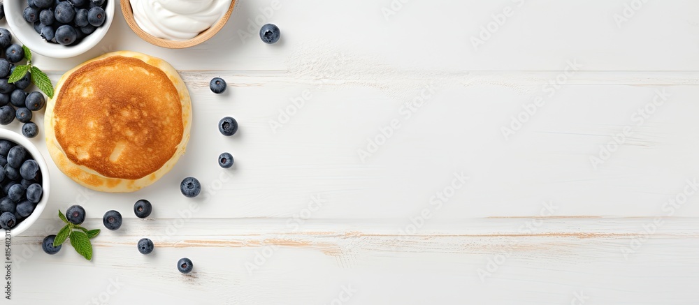 Poster Top view of a copy space image featuring light background with cottage cheese pancakes sour cream and blueberries Suitable for breakfast or lunch