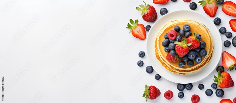 Poster a trendy breakfast featuring tiny homemade pancakes topped with blueberries and strawberries on a wh