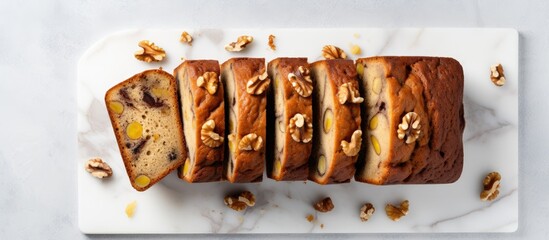 A sliced banana bread with walnuts arranged on a marble surface Top view providing room for design or text elements. Creative banner. Copyspace image