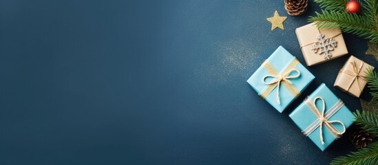 Top view flat lay of Christmas gift boxes and a fir tree on a blue background providing copy space for your greetings