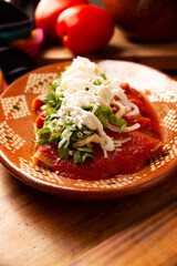 Entomatadas. Also known as Enjitomatadas, a typical dish of Mexican cuisine prepared with corn tortilla, tomato sauce and stuffed with shredded chicken meat. Classic homemade recipe.