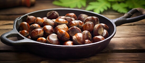 Chestnuts perfectly roasted and served in a rustic chestnut pan rest on a vintage table creating a charming copy space image
