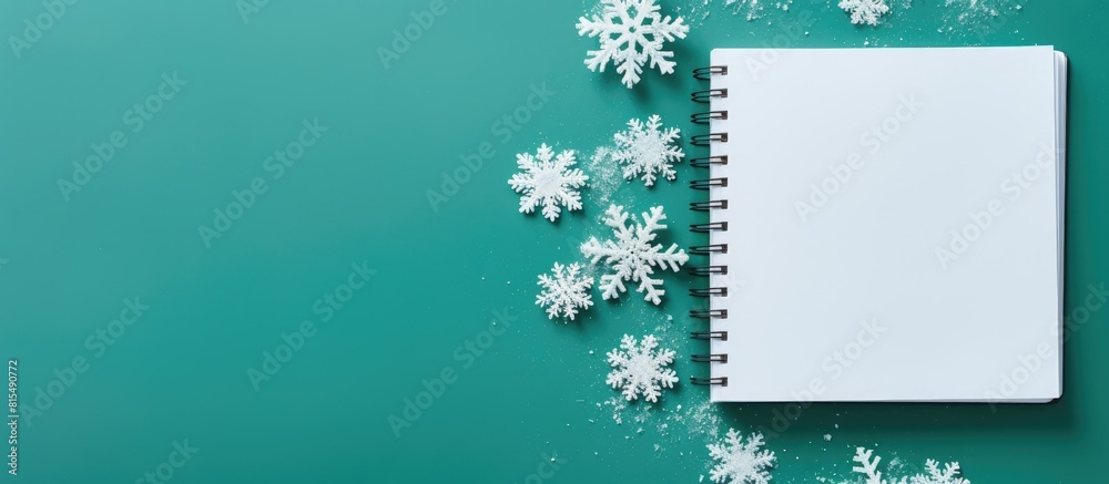 Leinwandbilder The image depicts an open notebook alongside delicate snowflakes set against a vibrant green background This top down view offers ample space for personalization or additional elements