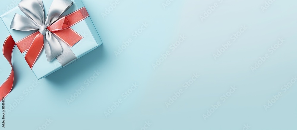 Poster Top view of a light blue background with a Christmas gift ribbons and ample space for text creating a visually pleasing copy space image