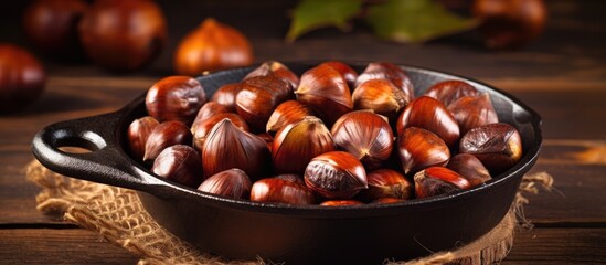 Chestnuts perfectly roasted and served in a rustic chestnut pan rest on a vintage table creating a charming copy space image