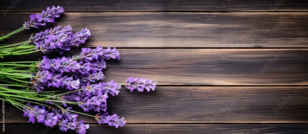 Poster Top view of a bouquet of fresh lavender flowers on a wooden background creating a copy space image for your text