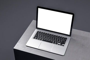 Elegant laptop showcasing a blank white screen on a dark podium, perfect for digital marketing presentations. 3D Render
