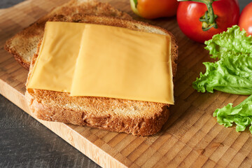 Delicious cheese sandwich on wooden board, closeup. Delicious breakfast