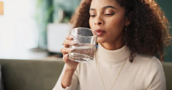 Drinking water, glass and medicine with woman in living room of home for tablet treatment of condition or symptoms. Healthcare, medical and supplement pill with person taking medication in apartment
