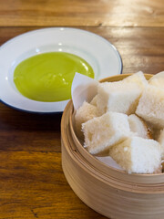 Pandan Kaya with Steamed Bread in bammboo basket. Steamed bun served with sweet green custard dip.