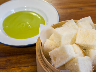 Pandan Kaya with Steamed Bread in bammboo basket. Steamed bun served with sweet green custard dip.